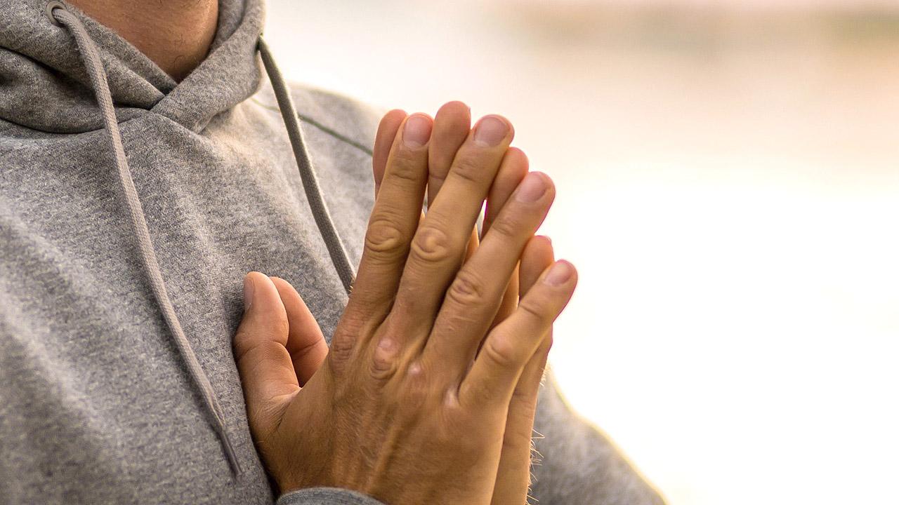 Betender Mann im Hoodie