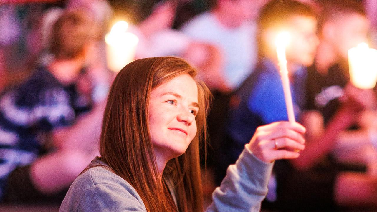 Ein Mädchen hält eine Kerze