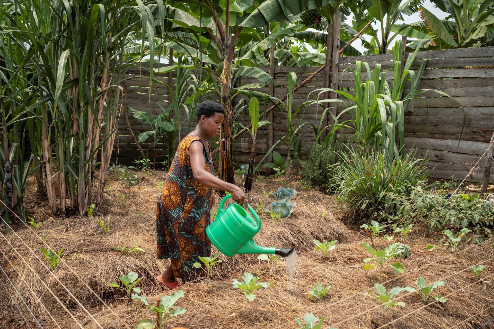 Frau mit Gießklanne im Garten