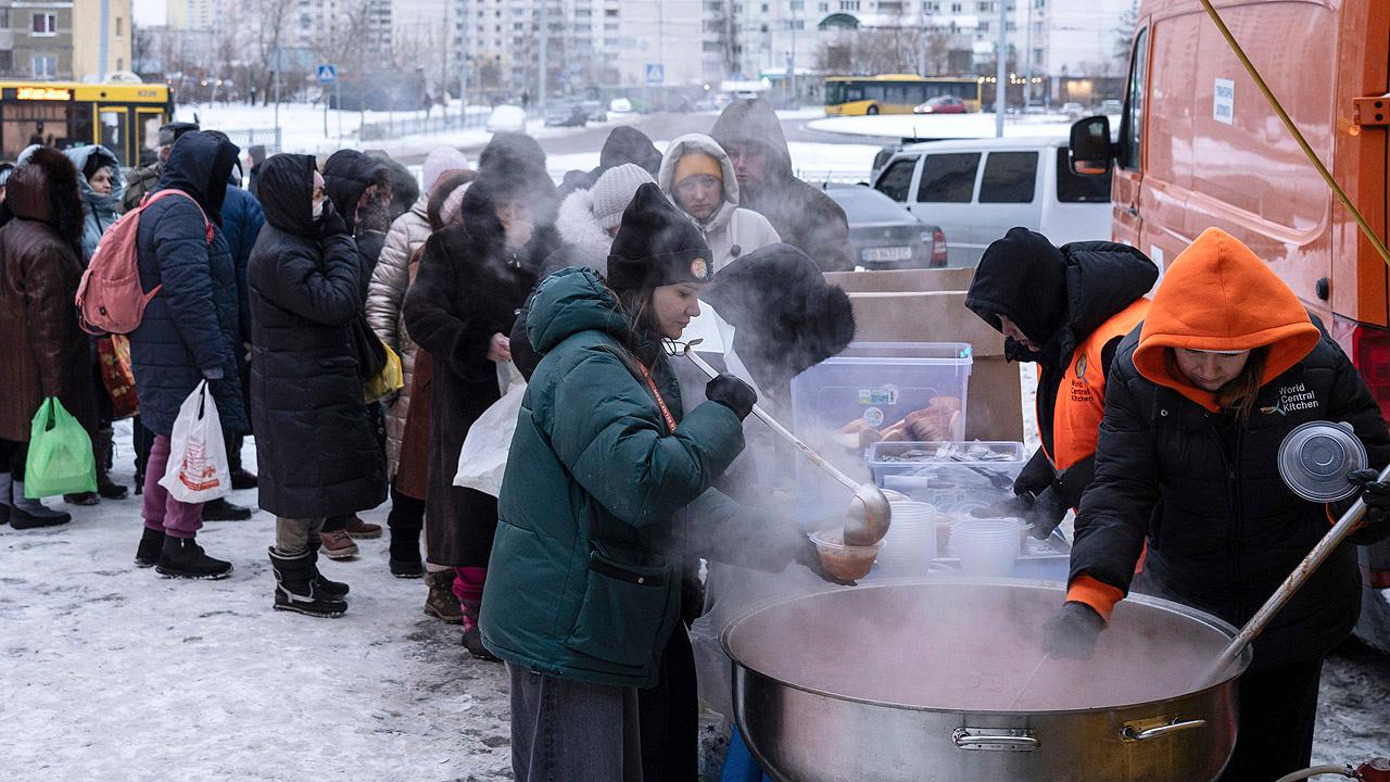 Winterhilfe Ukraine Großer Suppentopf, dahinter eine Menschenschlange