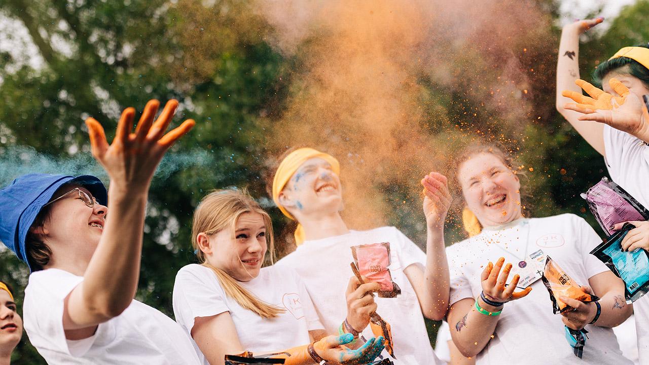 Jugendliche bewerfen sich mit Farbpulver und haben Spaß