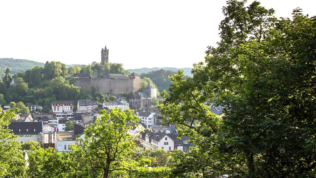 Propstei Nord-Nassau Eine Burg im Hintergrund, davor eine Kleinstadt
