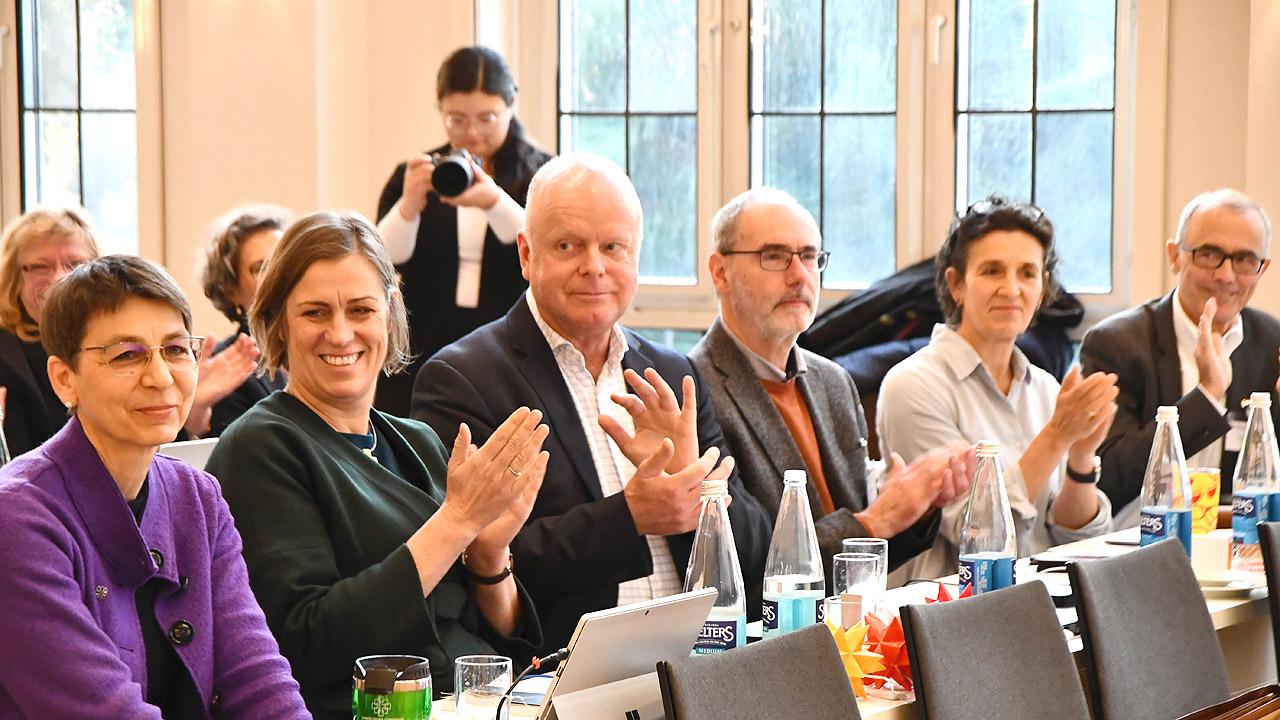 Pröpste Applaudierende Pröpste in einer Bankreihe