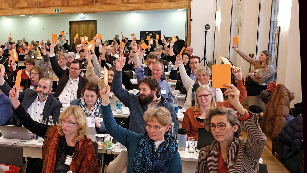 Synode Synodale heben Hand mit orangener Karte