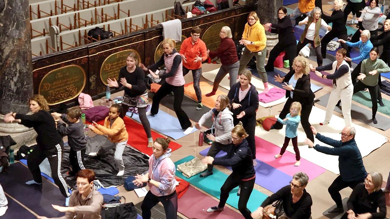 Viele Menschen machen Yogaübungen in einer Kirche
