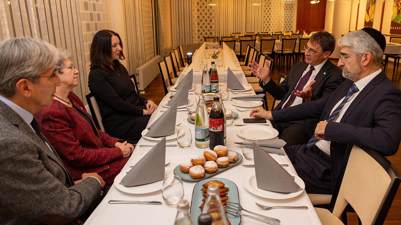 Christlich-jüdischer Dialog Die Vertreter beider Religionen sitzen an einem Tisch und unterhalten sich