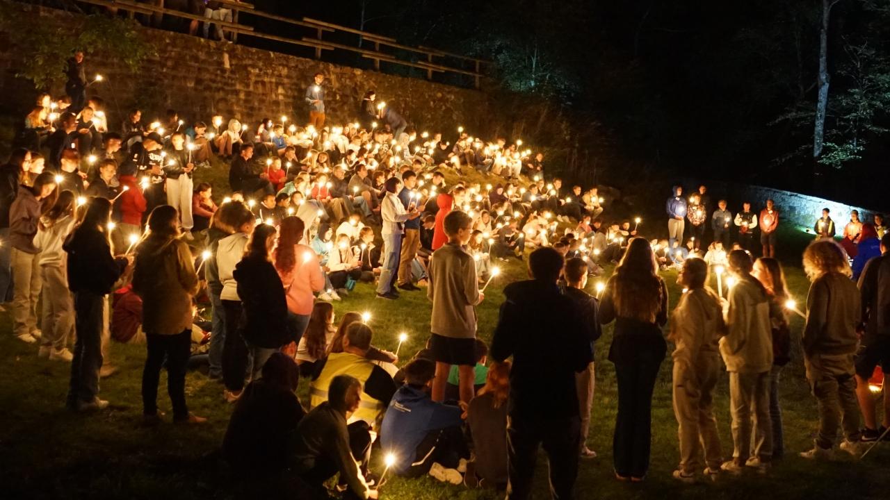 Viele Jugendliche mit Kerzenlicht in der Nacht