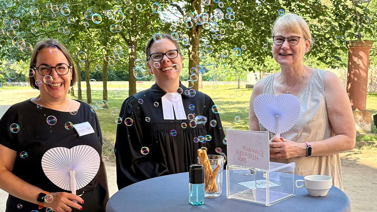 Seifenblasen Pfarrerin und zwei Frauen, davor Seifenblasen
