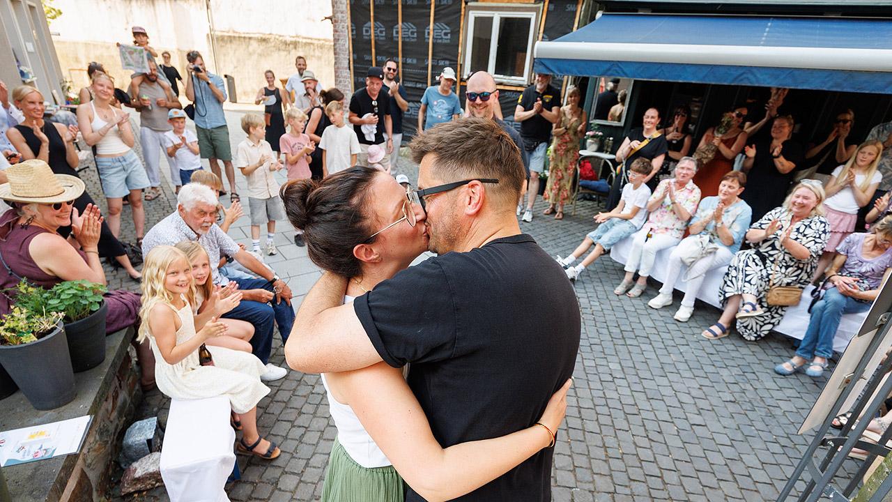 einfach heiraten Ein Paar küsst sich, andere applaudieren