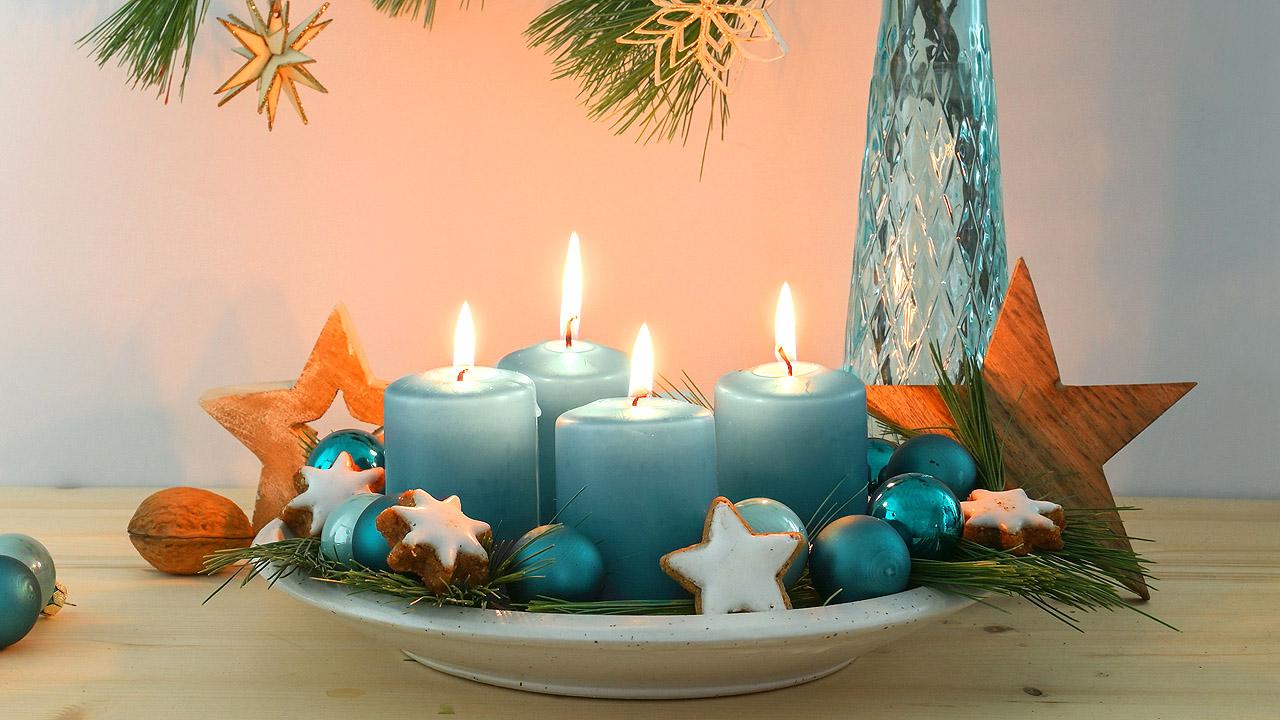 Adventskranz Kerzen auf einem Teller und etwas Tannengrün (Kerzen sollten sicherheitshalber auf Untersetzern stehen)