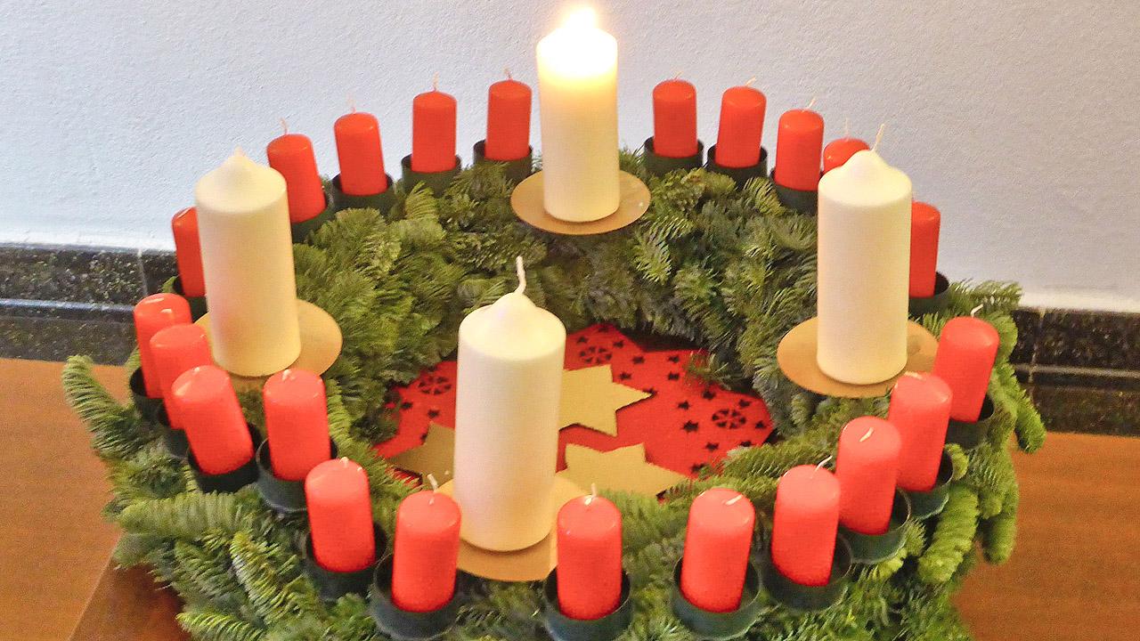 Wichern-Adventskranz Adventskranz mit vier großen weißen Kerzen, dazwischen viele kleine, rote Kerzen