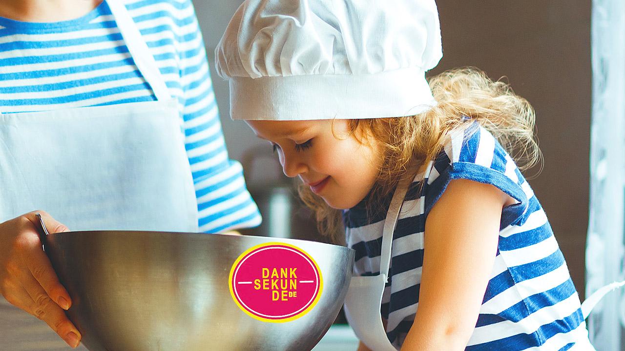 Ein Kind schaut in eine Rührschüssel, auf der Danksekunde steht