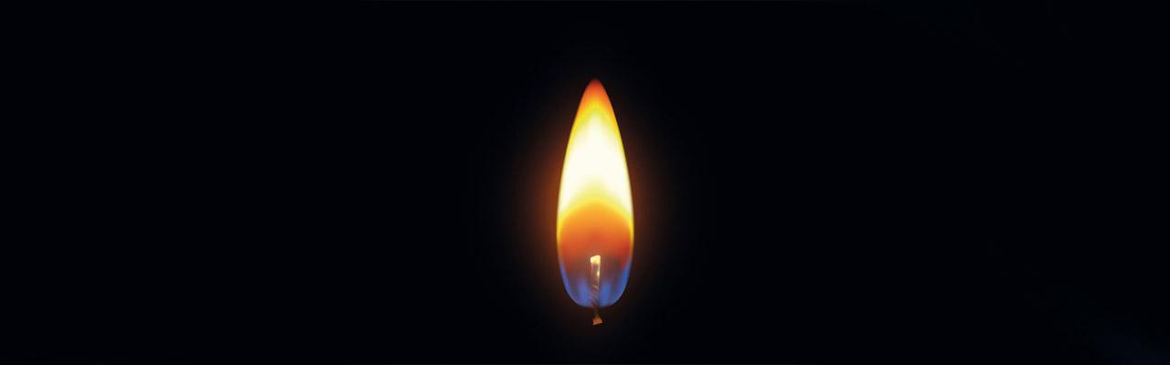 Osternacht Kerzenflamme inmitten von Dunkelheit