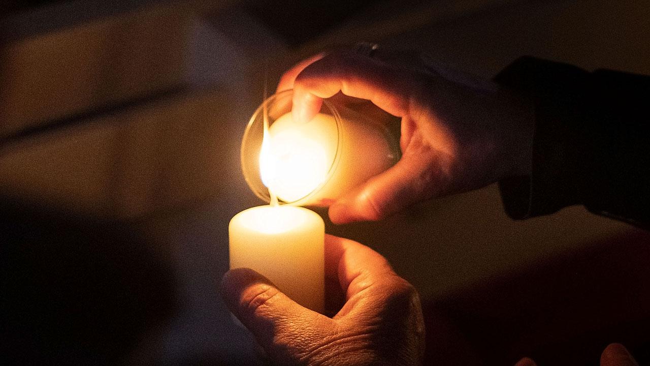 Osterkerze Eine Kerze wird an einer anderen Kerze entzündet