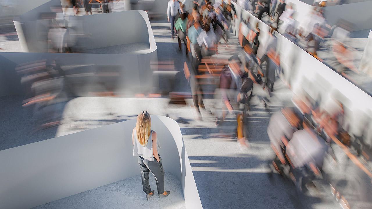 Eine isoliert stehende Frau schaut zu, wie Menschen orientierungslos durch ein Labyrinth eilen
