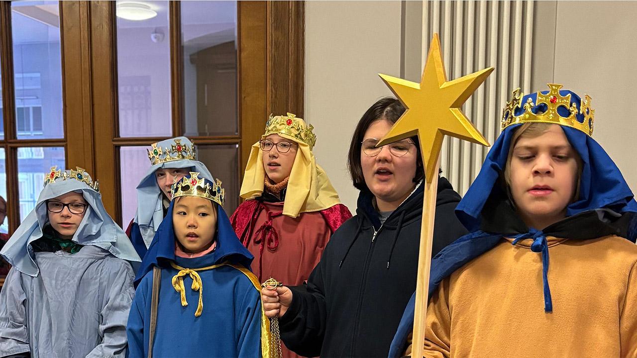 Gruppenbild mit Kindern, die als Könige verkleidet sind mit Pappstern an einem Stab