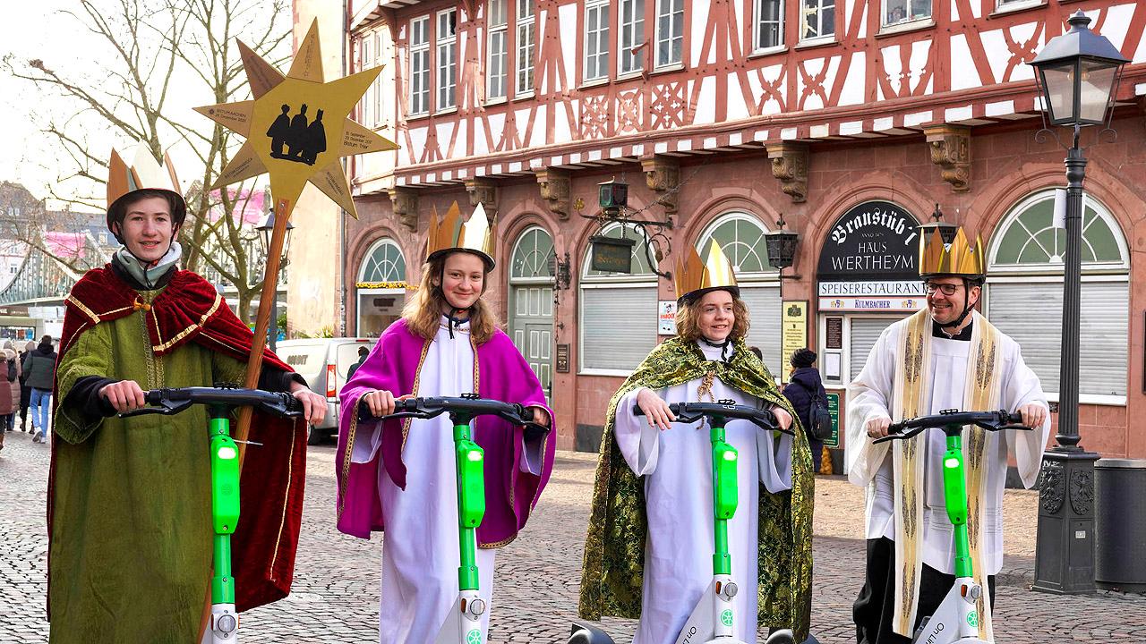 Jugendliche als verkleidete Könige auf Rollern in Frankfurt am Main