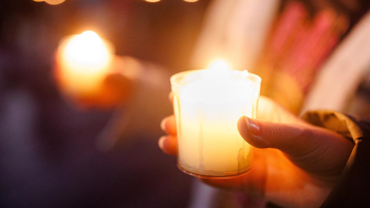 Friedenslicht Hand, die eine brennende Kerze hält