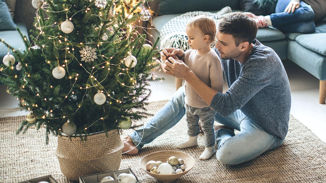 Weihnachtsbaum im Topf Weihnachtsbaum im Topf - Vater und kleines Kind schmücken ihn