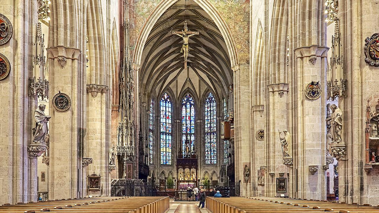 Ulmer Münster Gotischer Kirchenbau mit spitzen Bögen, im Chorraum hohe, farbige Glasfenster