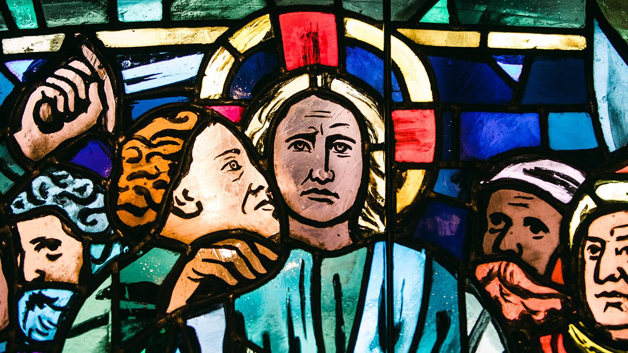 Kirchenfenster Judas Ein Mann küsst Jesus, der einen Heiligenschein hat
