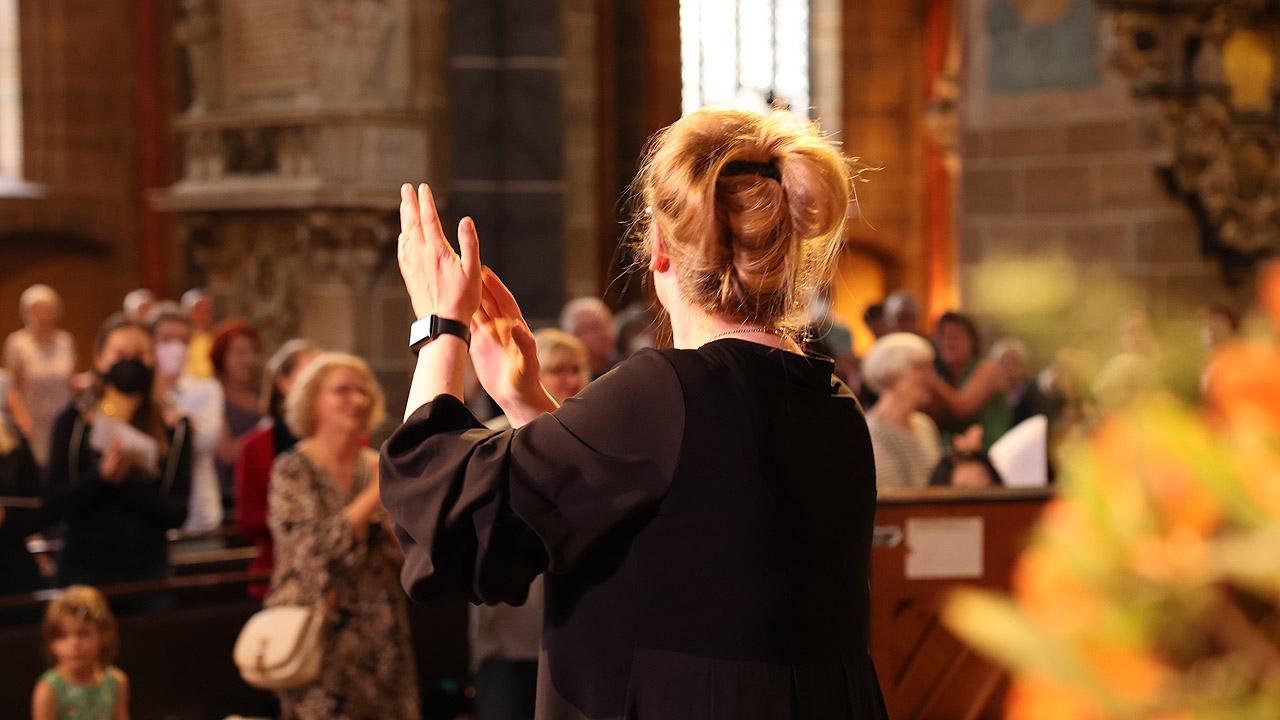 Dirigentin und Gemeinde  Dirigentin vor Gottesdienstbesuchern