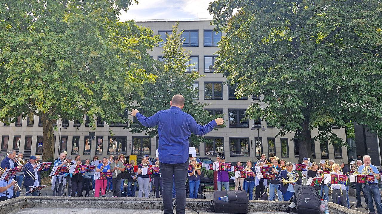 Platzkonzert Posaunenchor unter freiem Himmel vor Bäumen
