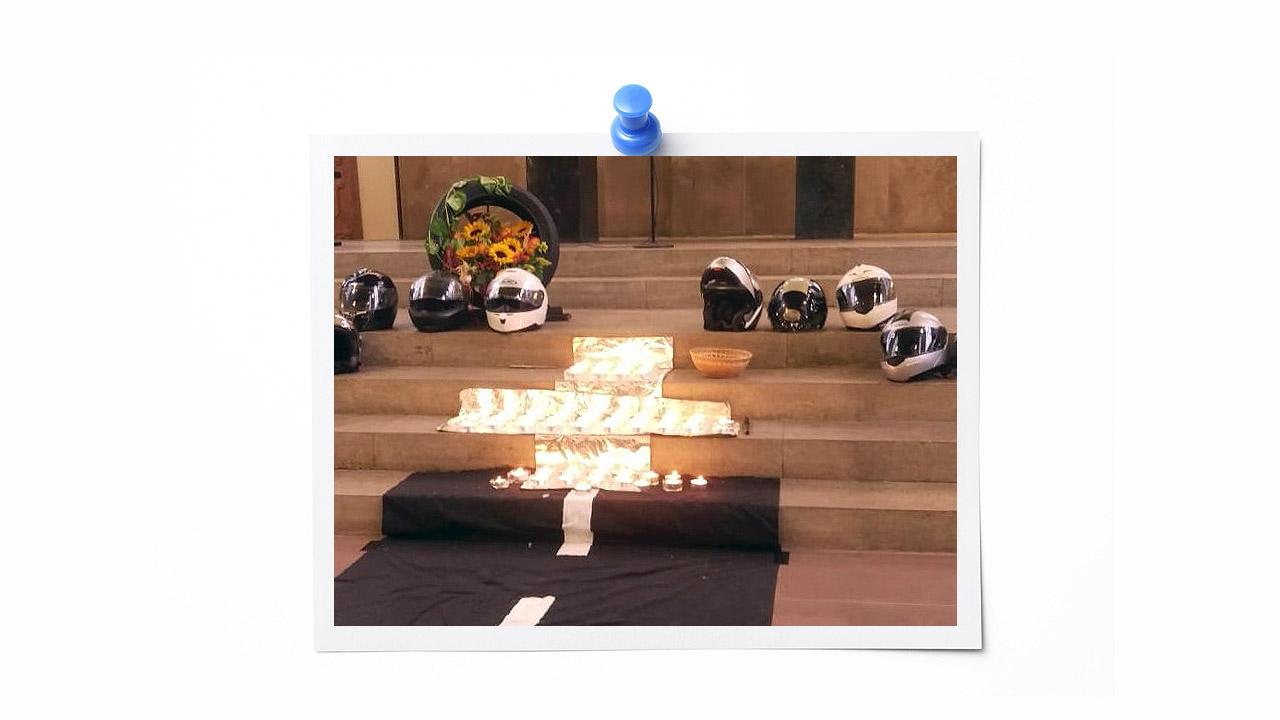 Gedenken Kerzen auf einer Treppe, darüber liegen Motorradhelme