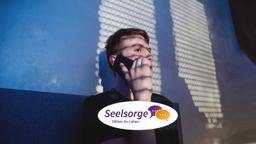 Ein junger Mann telefoniert im Dunklen