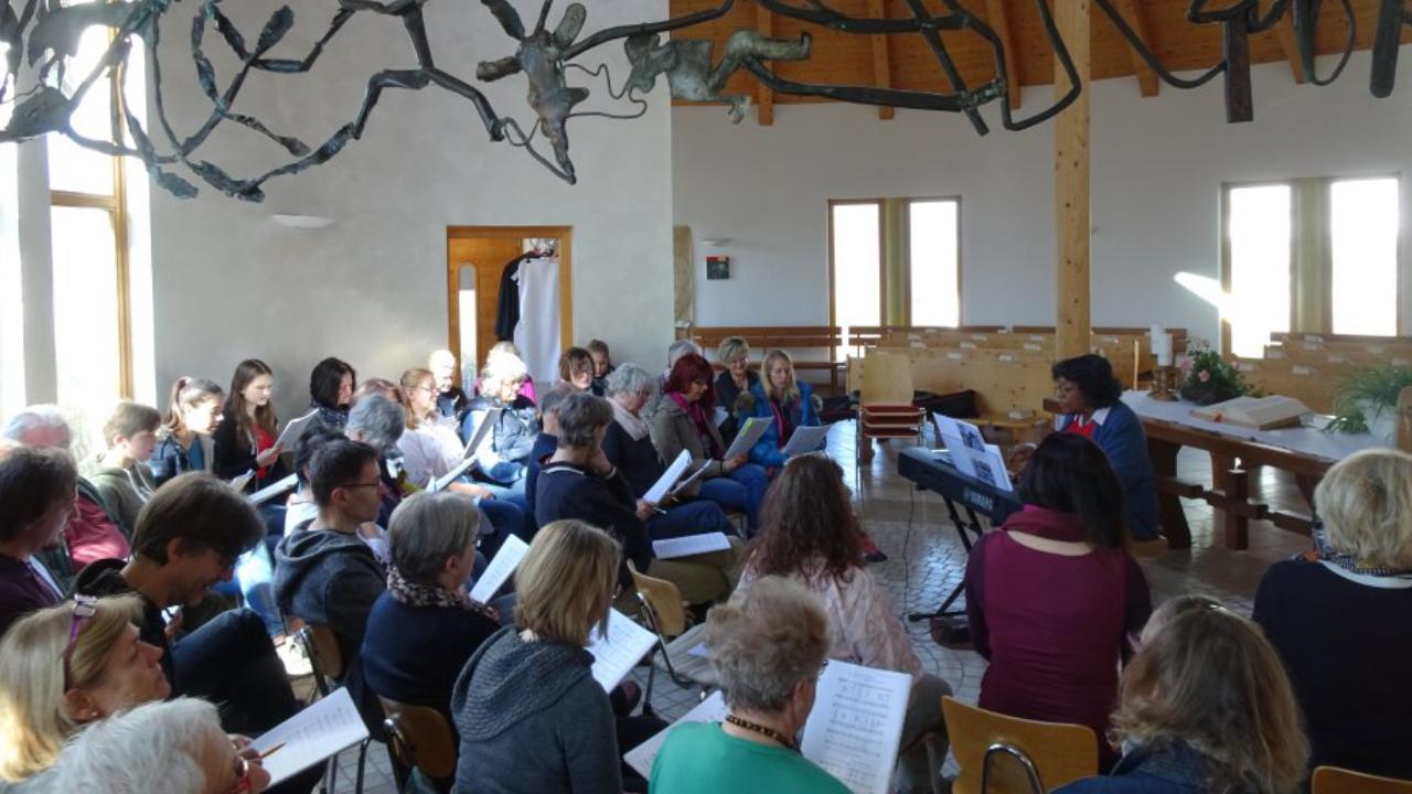 Flois Knolle-Hicks Gospelworkshop In der Kirche sitzen viele Menschen mit einem Liedblatt in der Hand. Flois Knolle-Hicks spielt Orgel
