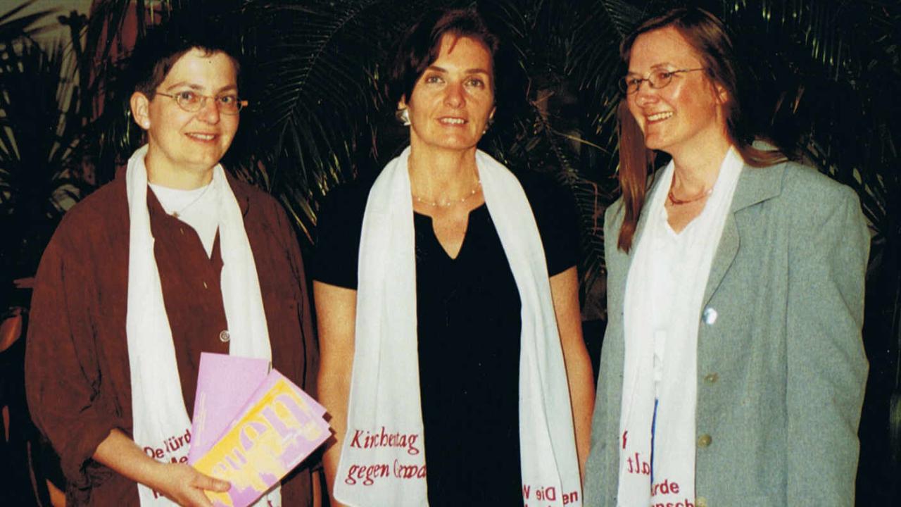 Sylvia Puchert, Helga Engler-Heidle und Christiane Wessels (v.l.) Sylvia Puchert, Helga Engler-Heidle und Christiane Wessels (v.l.) tragen alle einen weißen Kirchentagsschal und lächelnin die Kamera