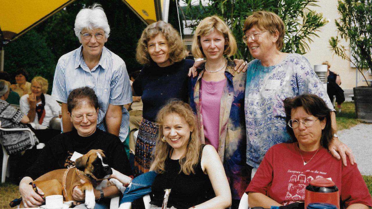 Engagierte Frauen auf der Europäischen Frauensynode in Österreich 1996 Sieben Frauen blicken in die Kamera, vier stehen, drei sitzen vor den Stehenden. Eine Frau hat einen kleinen Hund auf dem Schoß