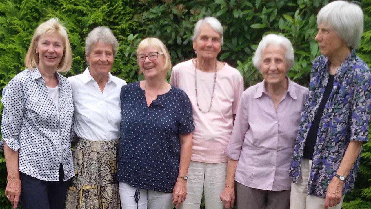 Friedensfrauen der ersten Stunde Auf dem Bild stehen die Frauen der Initiative Frauen-Frieden nebeneinander im Hintergrund befindet sich eine Hecke.