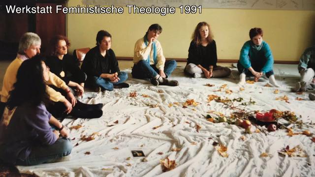 Werkstatt Feministische Theologie 1991 Frauen sitzen im Halbkreis auf dem Bogen vor ihnen ein großes Tuch in der Mitte eine Kerze und Zweige - eine Art Altar auf dem Boden