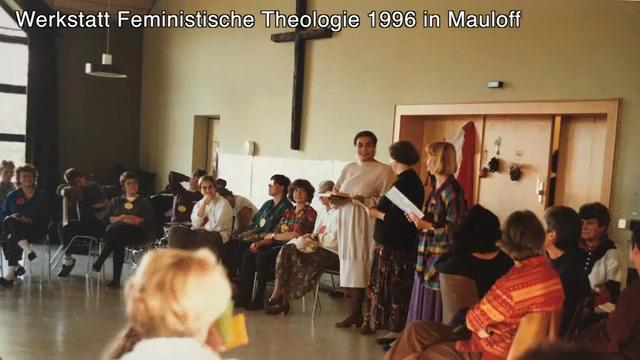 Werkstatt Feministische Theologie in Mauloff 1996 Frauen im Stuhlkreis, eine als Papst verkleidete Frau in weißem Gewand trägt etwas vor.