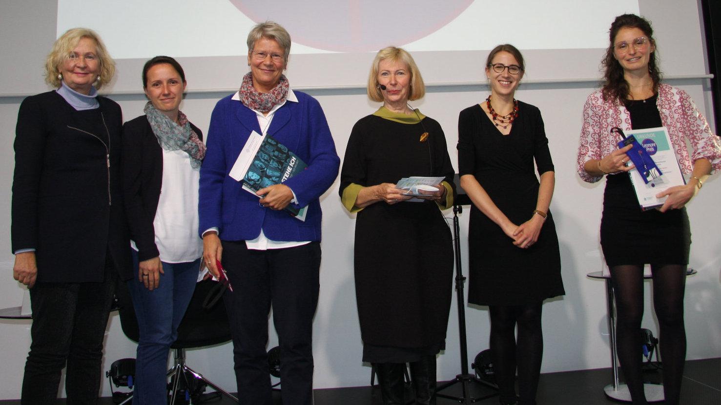Leonore Siegele-Wenschkewitz-Preisverleihung 2021 des Vereins zur Förderung Feministischer Theologie in Forschung und Lehre e.V. Die Preisträgerinnen und die Vereinsmitglieder stehen nebeneinander auf der Bühne.