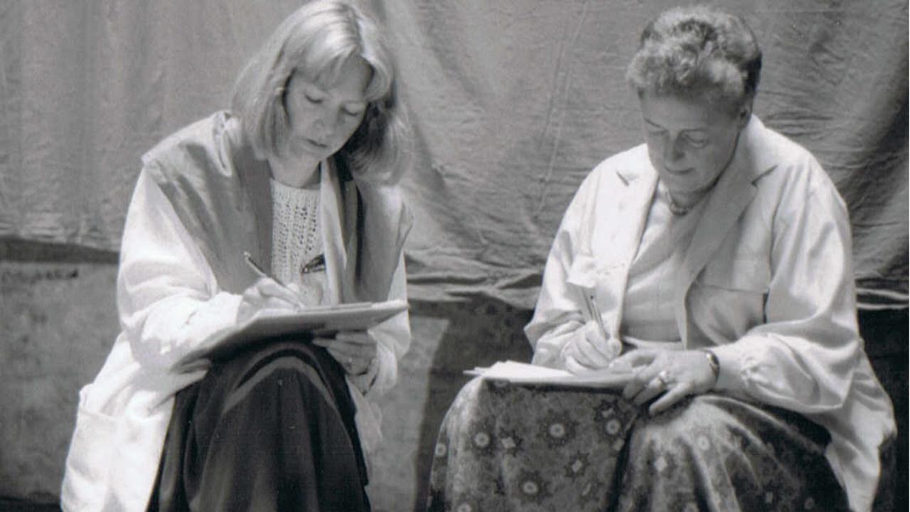 Ute Knie mit Eva Renate Schmidt Ute Knie und Eva Renate Schmidt sitzen auf Papphockern in einer Halle des Kirchentages in Frankfurtund machen sich Notizen