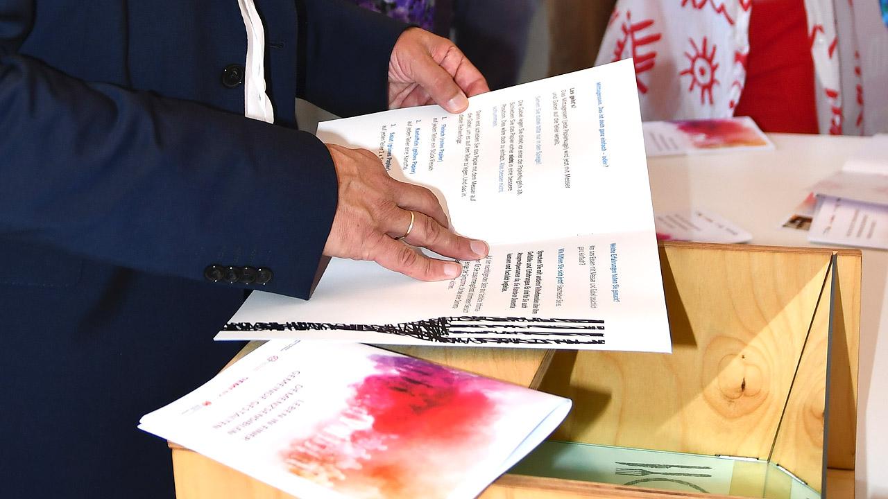 Demenzsimulator Begleitheft Hände halten ein Heft