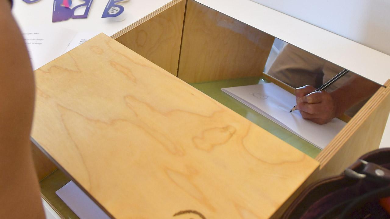 Demenzsimulator Eine Hand in einer Kiste, die zeichnet