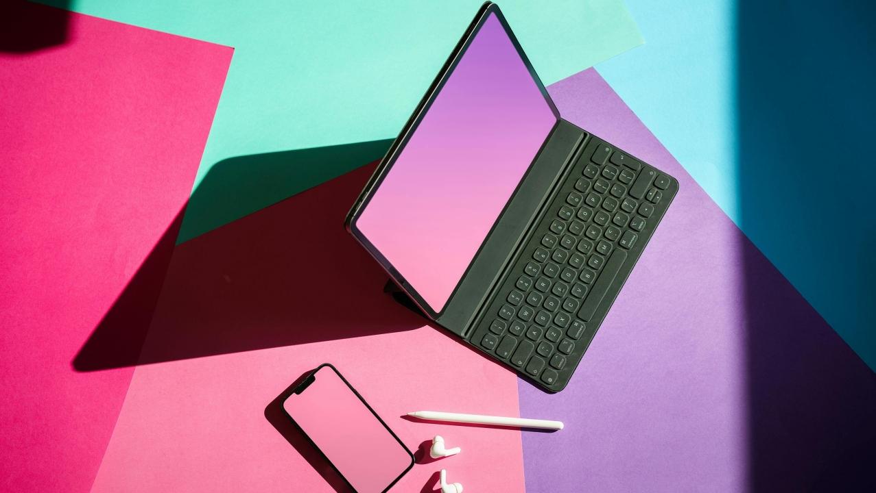 Notebook und Smartphone auf farbigen Flächen