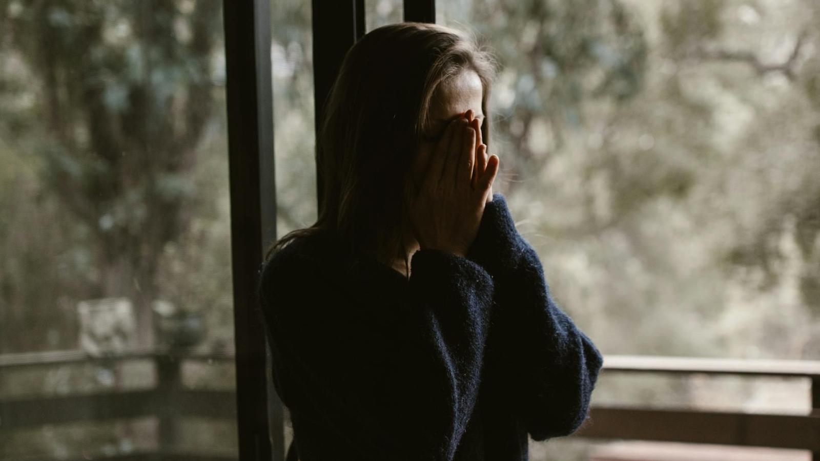 Frau hält sich ihre Hände vor das Gesicht