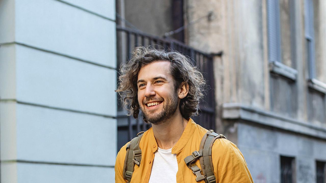 Mann mit Rucksack in einer Stadt