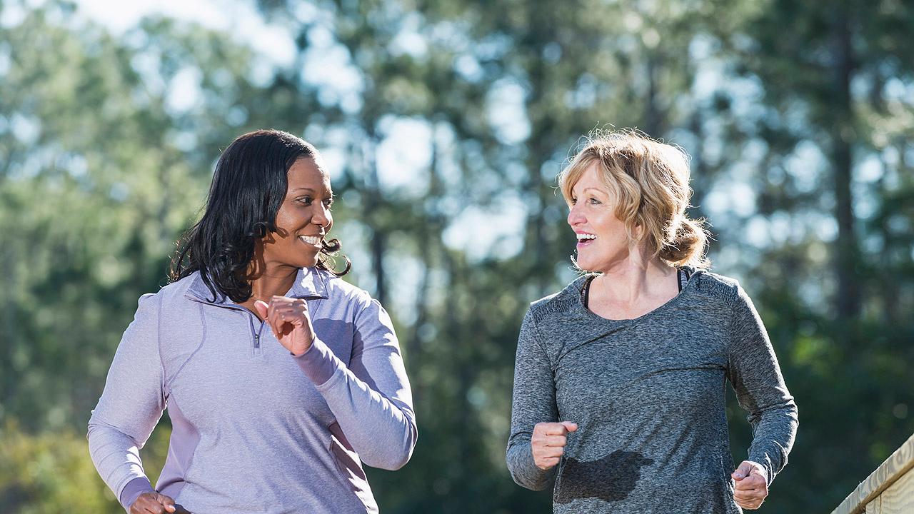 Gespräch beim Laufen Zwei Frauen unterhalten sich beim Joggen
