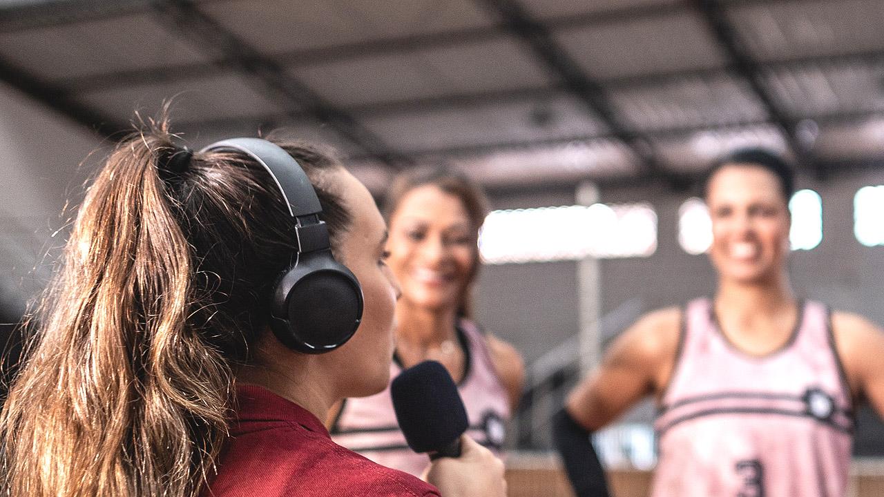 Eine Frau interviewt Volleyballerinnen