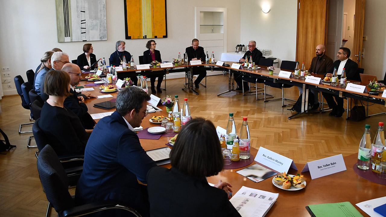 Ökumene-Treffen Menschen an einem Konferenztisch