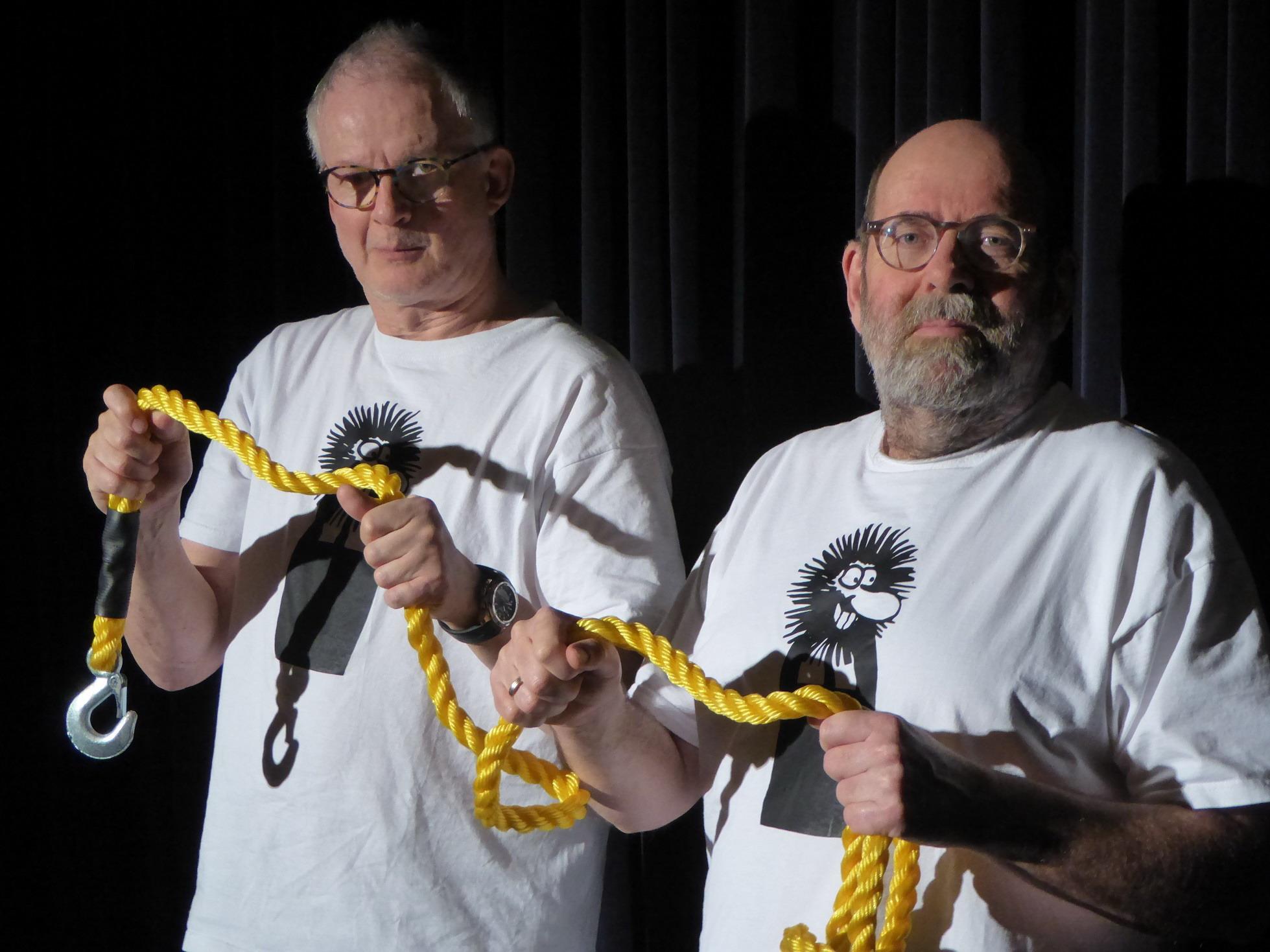 Greifenstein und Herrmann auf der Bühne, halten gemeinsam ein Seil in der Hand