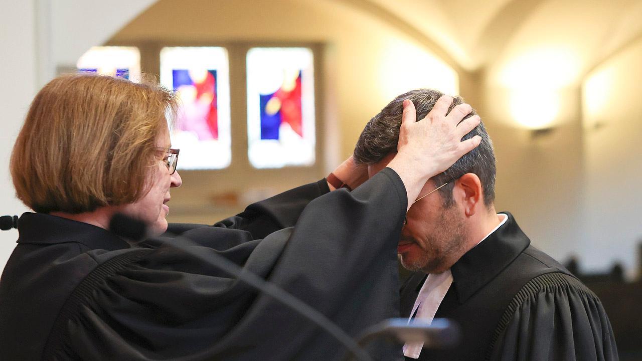 Ulrike Scherf und André Witte-Karp Ulrike Scherf mit segnender Geste gegenüber André Witte-Karp