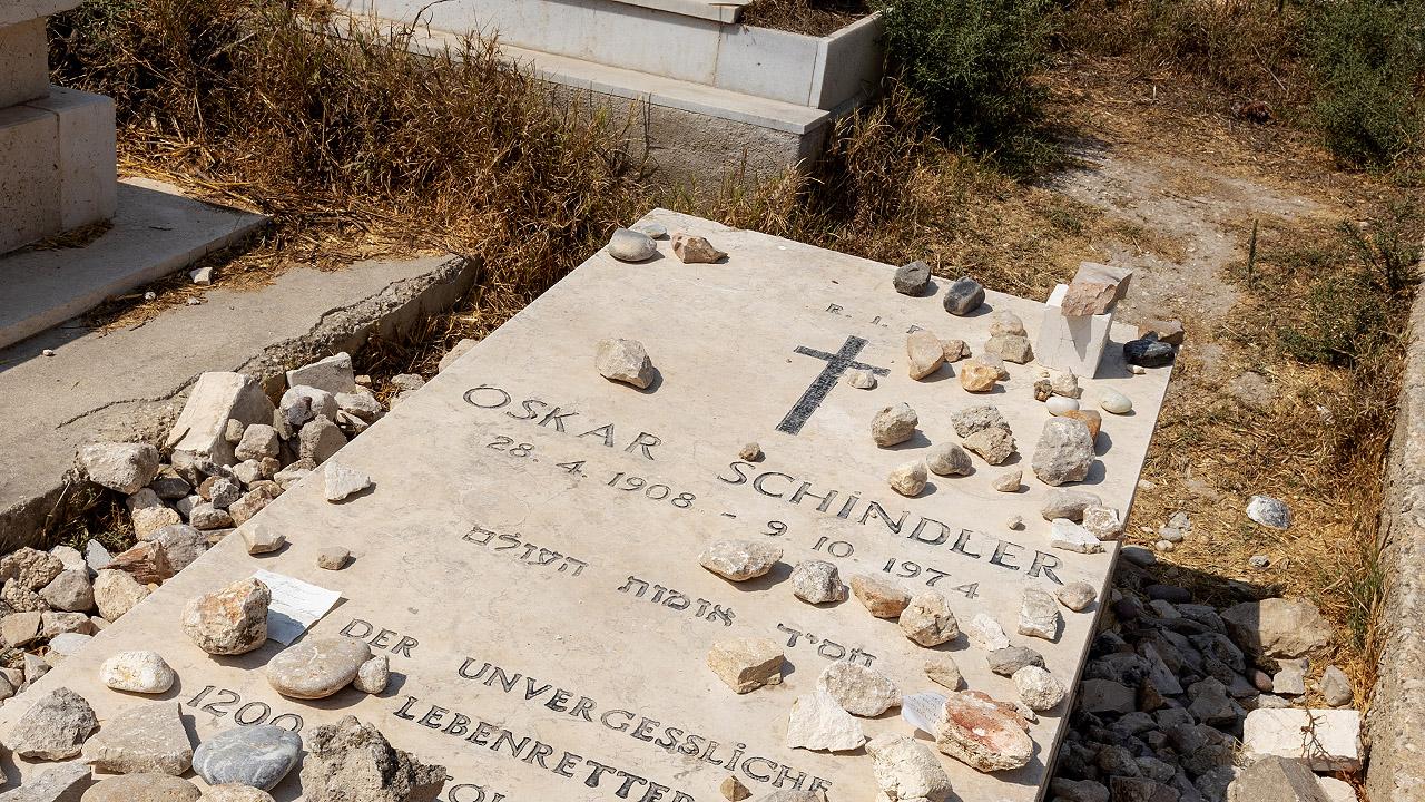 Steinplatte mit dem Namen Oskar Schindler, darauf liegen kleinere Steinchen