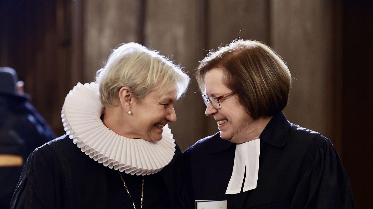 Kirsten Fehrs und Ulrike Scherf Zwei weibliche Pfarrpersonen im Talar, Kirsten Fehrs mit großer, weißer Halskrause, Ulrike Scherf mit Bäffchen