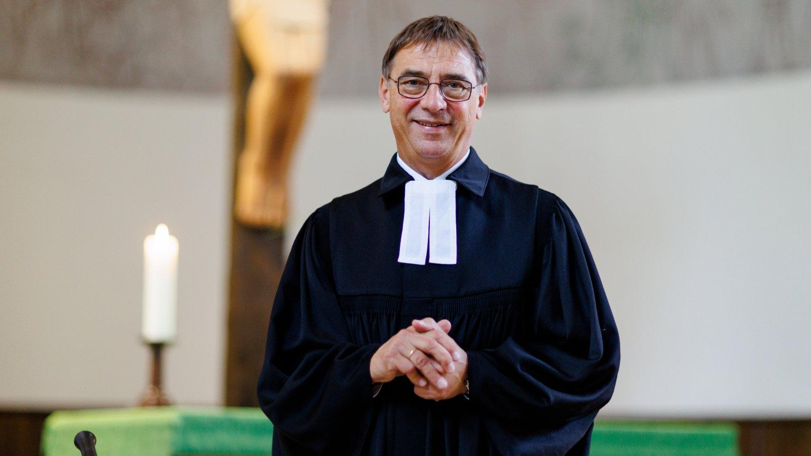 Portrait, steht vor dem Altar mit einer brennenden Kerze